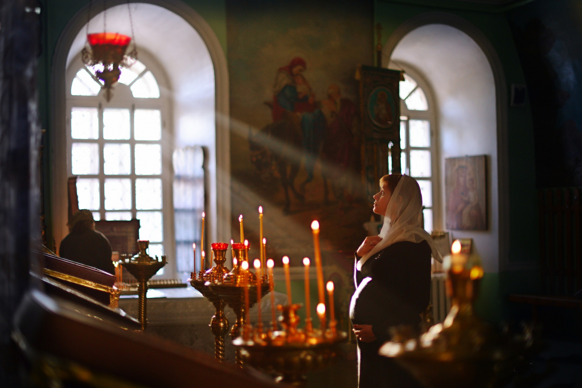 Молитва православной женщины. Мольба у иконы Николая Чудотворца. Женщина молится в церкви. Женщина в храме. Человек молится в храме.